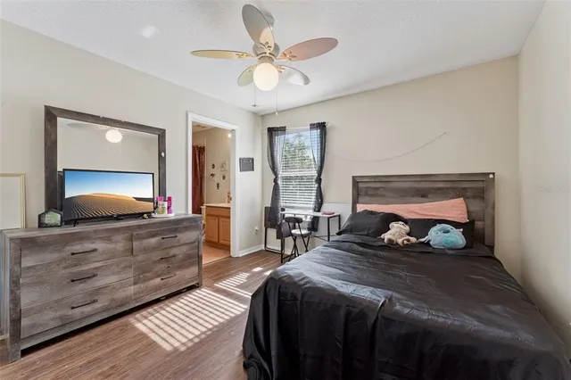 a bedroom with a bed and a flat tv screen on dresser