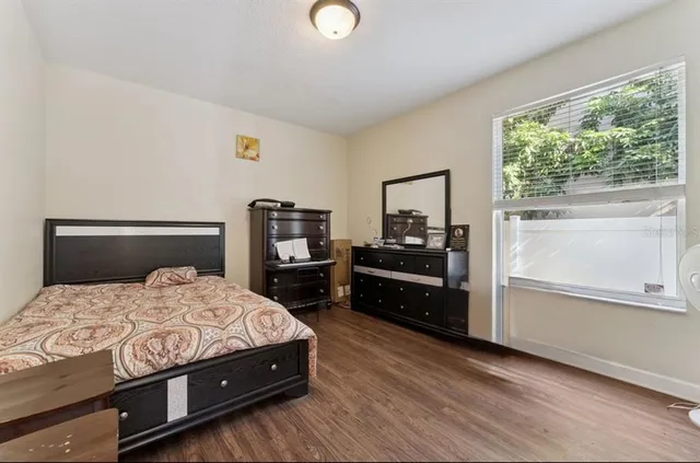 a bedroom with a bed and a dresser next to a window