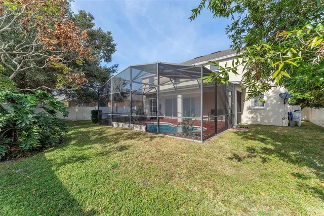 a view of a house with a large tree and a yard