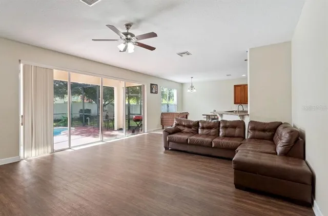 a living room with furniture and a large window with wooden floor