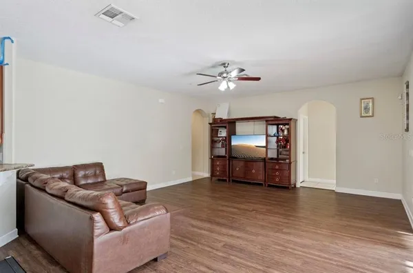 a living room with furniture and a wooden floor