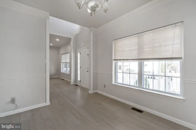 an empty room with wooden floor a fireplace and window