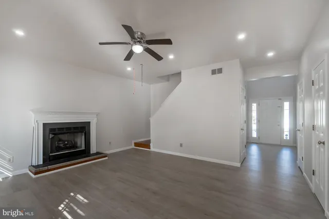 an empty room with windows and fireplace