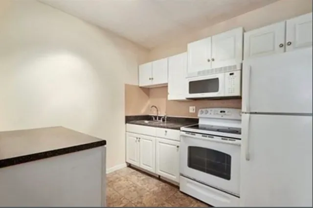 a kitchen with cabinets stainless steel appliances and sink