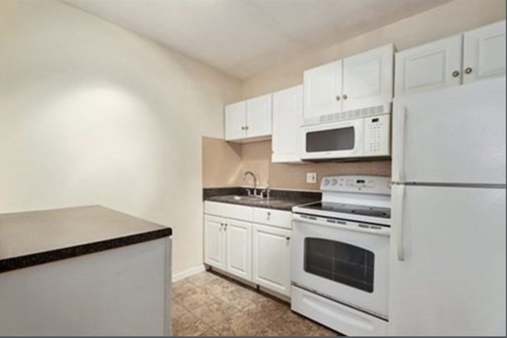 116 Spring Street, Unit A4 Boston, MA 02132 - Photo 1 of 7 a kitchen with cabinets stainless steel appliances and sink