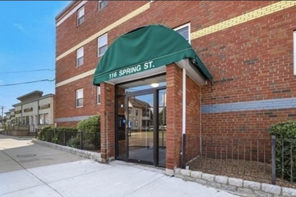 116 Spring Street, Unit A4 Boston, MA 02132 - Photo 7 of 7 a view of a brick building with a large windows