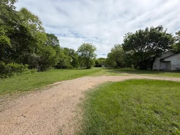 a view of a grassy field with trees in the background