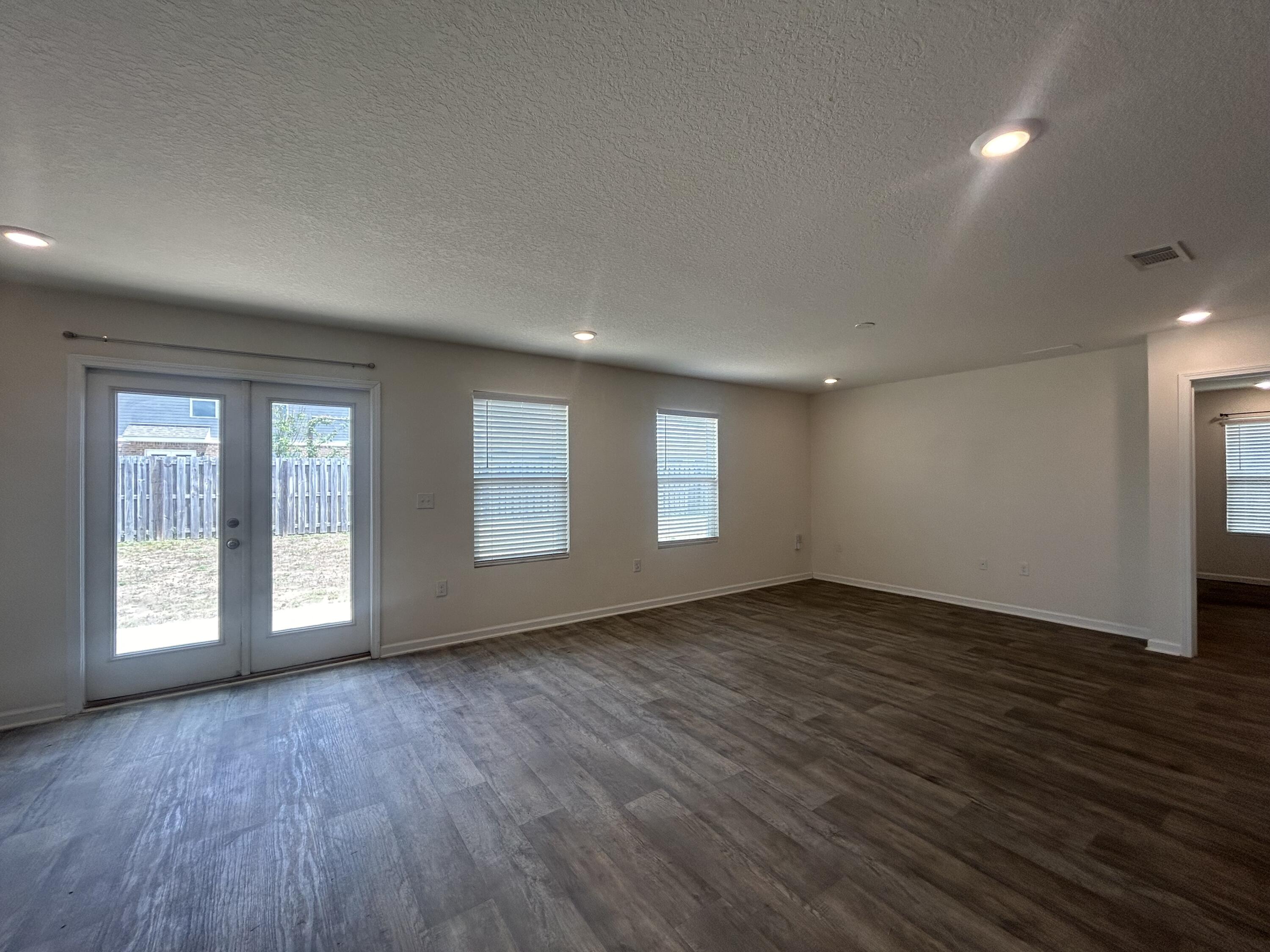 916 Merganser Way Crestview, FL 32539 - Photo 17 of 37 an empty room with wooden floor and windows