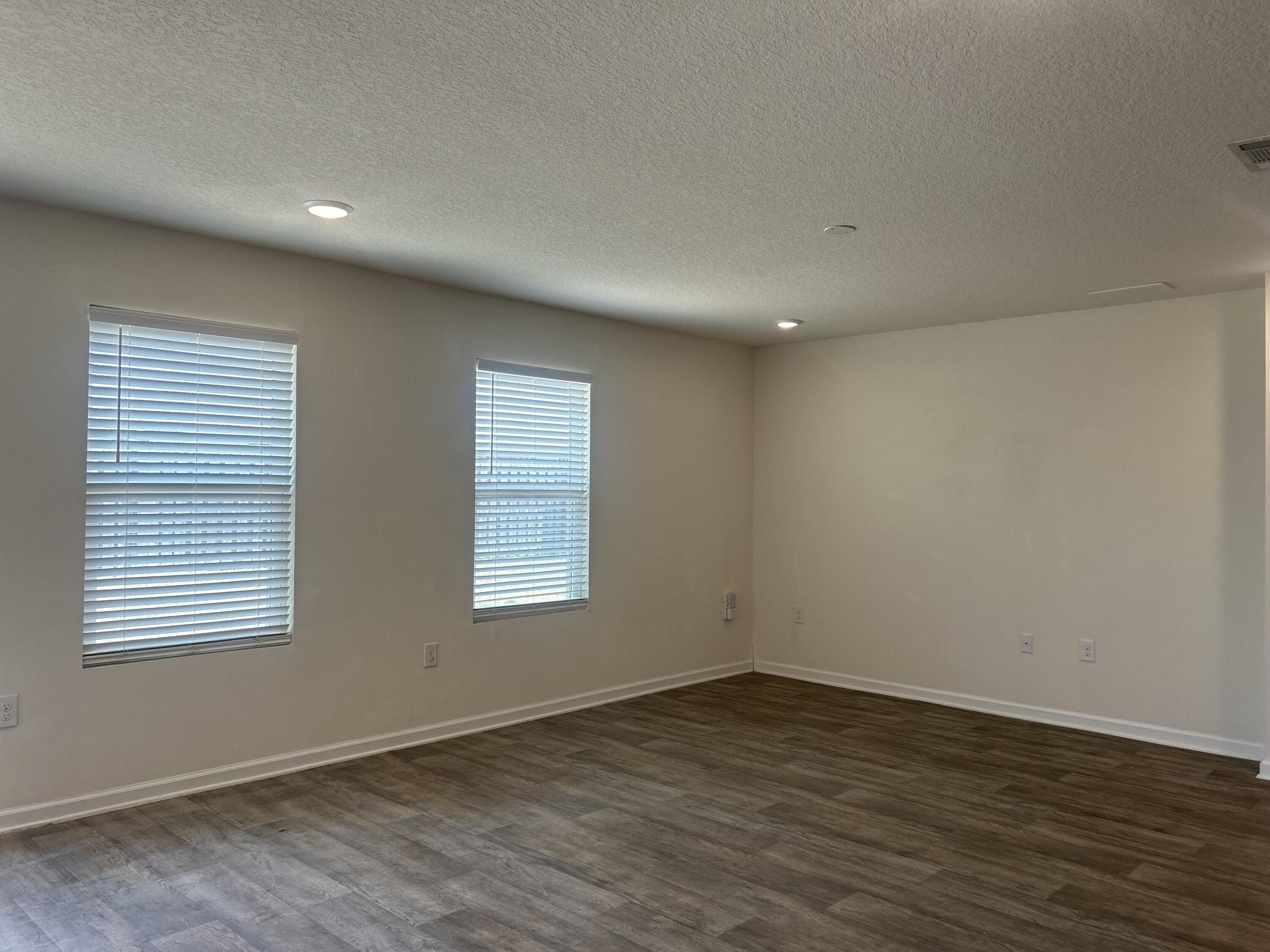 916 Merganser Way Crestview, FL 32539 - Photo 18 of 37 an empty room with wooden floor and windows