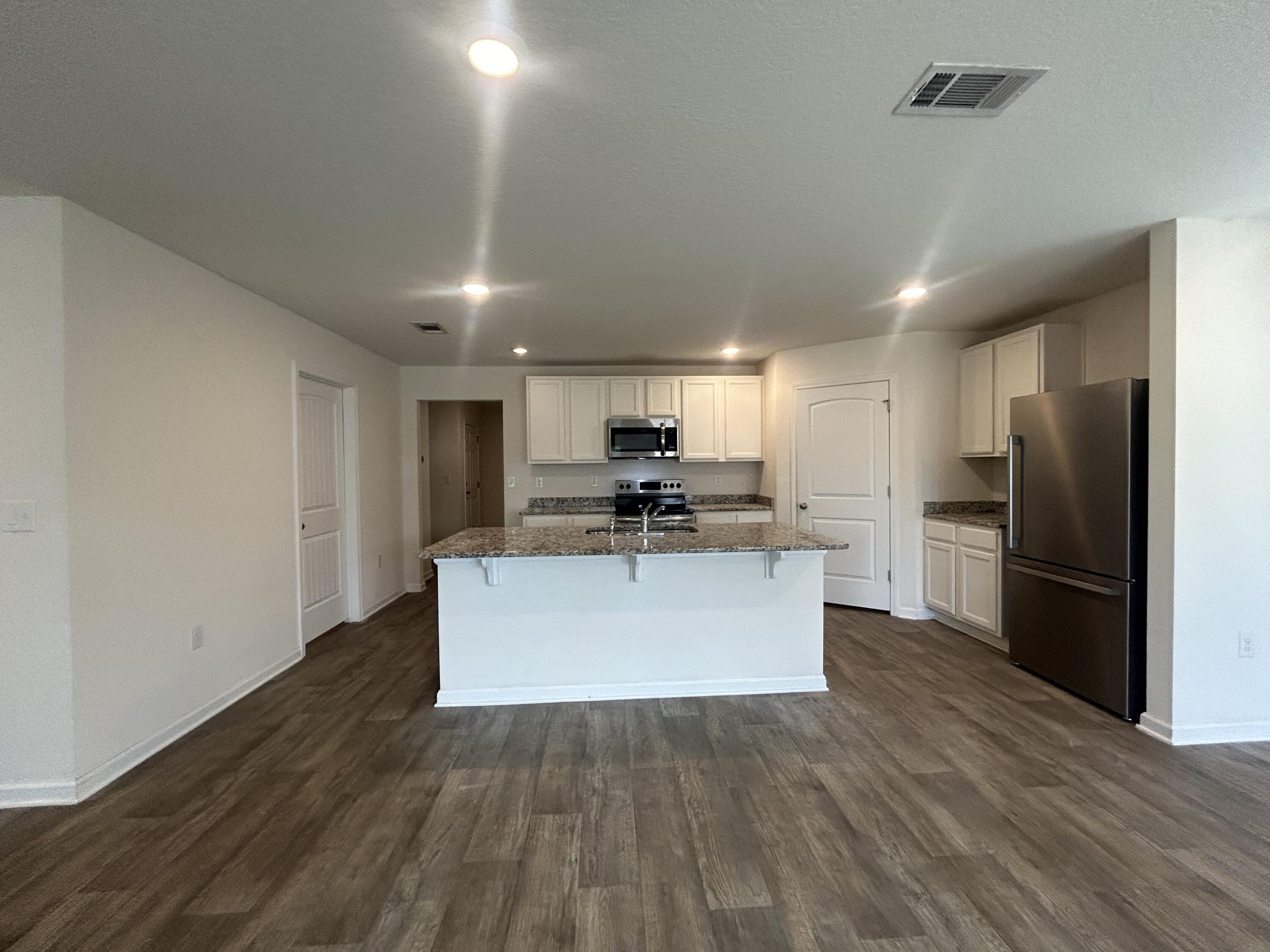 916 Merganser Way Crestview, FL 32539 - Photo 19 of 37 a large kitchen with stainless steel appliances a large counter top and a stove top oven