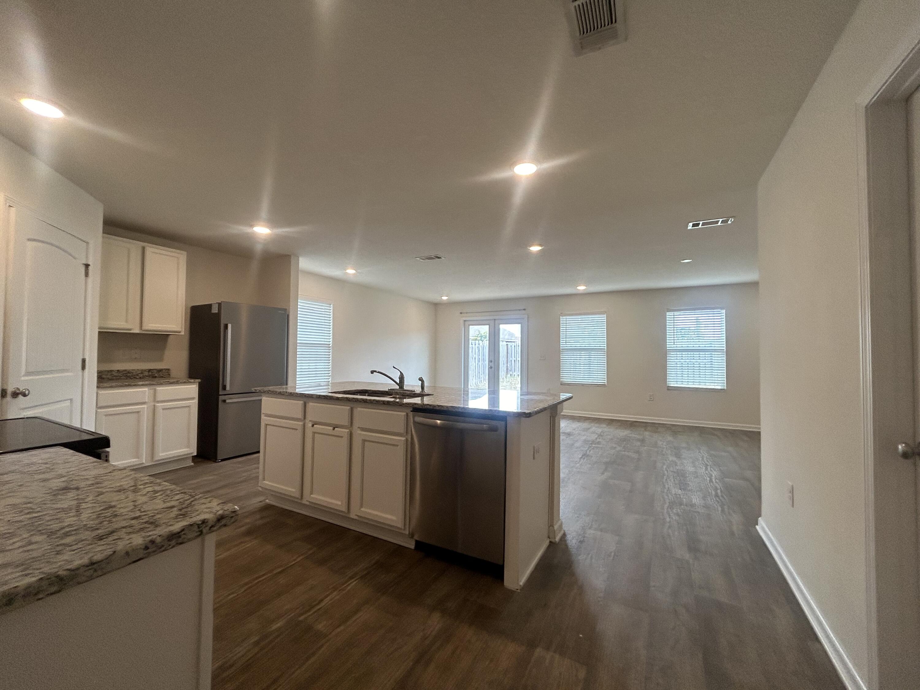 916 Merganser Way Crestview, FL 32539 - Photo 3 of 37 a kitchen with stainless steel appliances granite countertop a stove a sink and a refrigerator