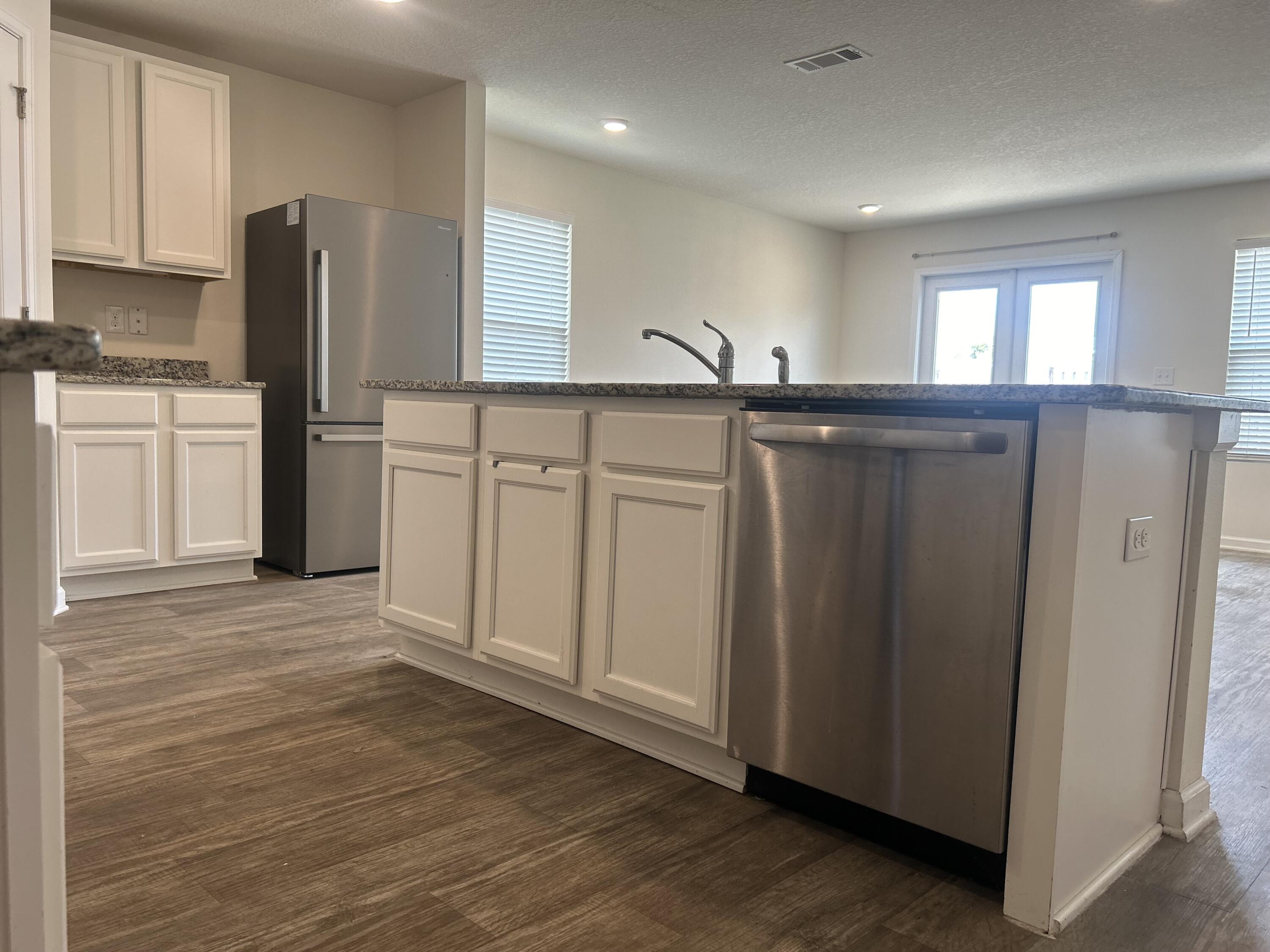 916 Merganser Way Crestview, FL 32539 - Photo 5 of 37 a kitchen with stainless steel appliances granite countertop a refrigerator and a stove top oven