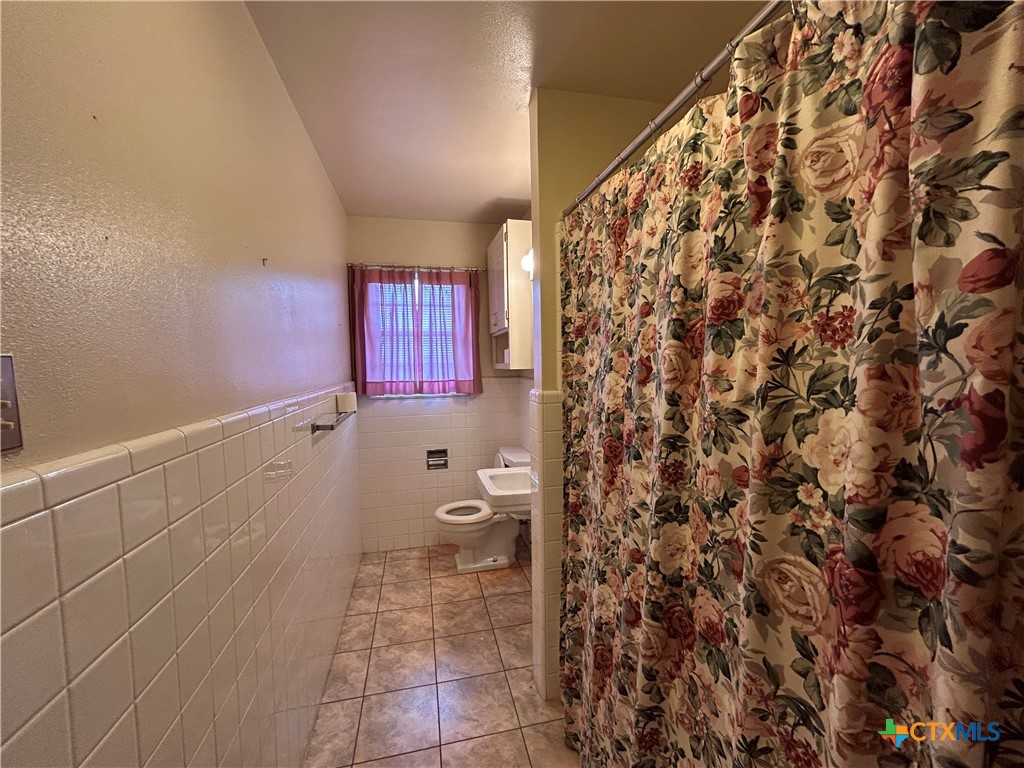 614 Apollo Drive Edna, TX 77957 - Photo 17 of 41 a bathroom with a toilet and a shower curtain