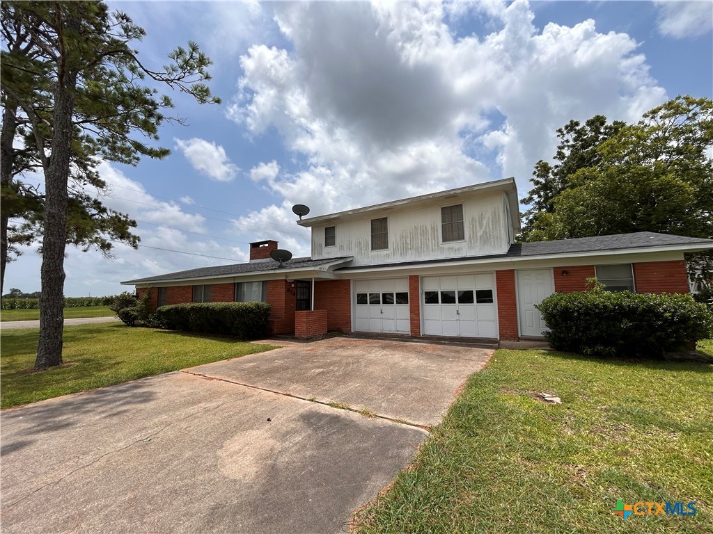 614 Apollo Drive Edna, TX 77957 - Photo 2 of 41 a front view of a house with a garden and yard