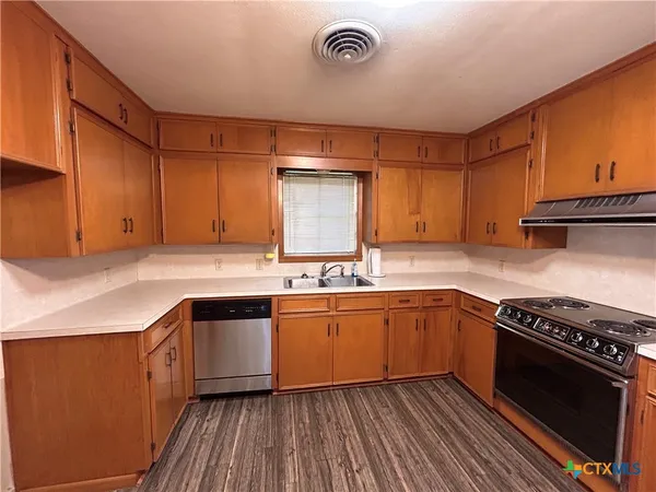 a kitchen with stainless steel appliances granite countertop a stove a sink and a refrigerator