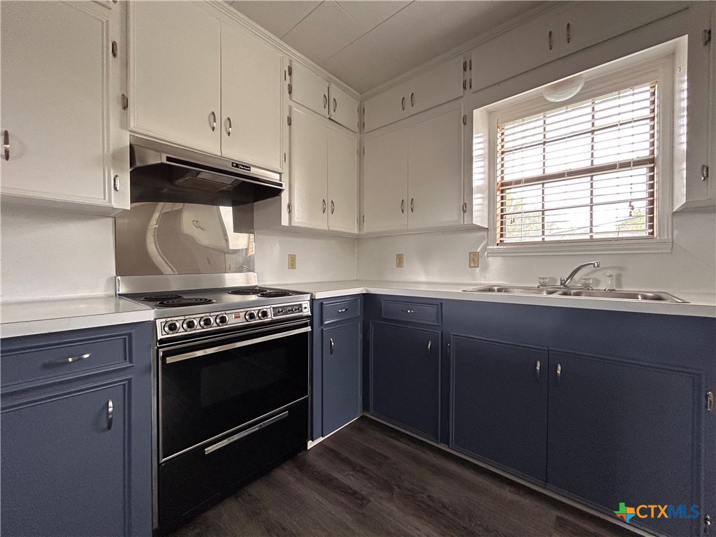 614 Apollo Drive Edna, TX 77957 - Photo 32 of 41 a kitchen with granite countertop wooden cabinets stove top oven and sink