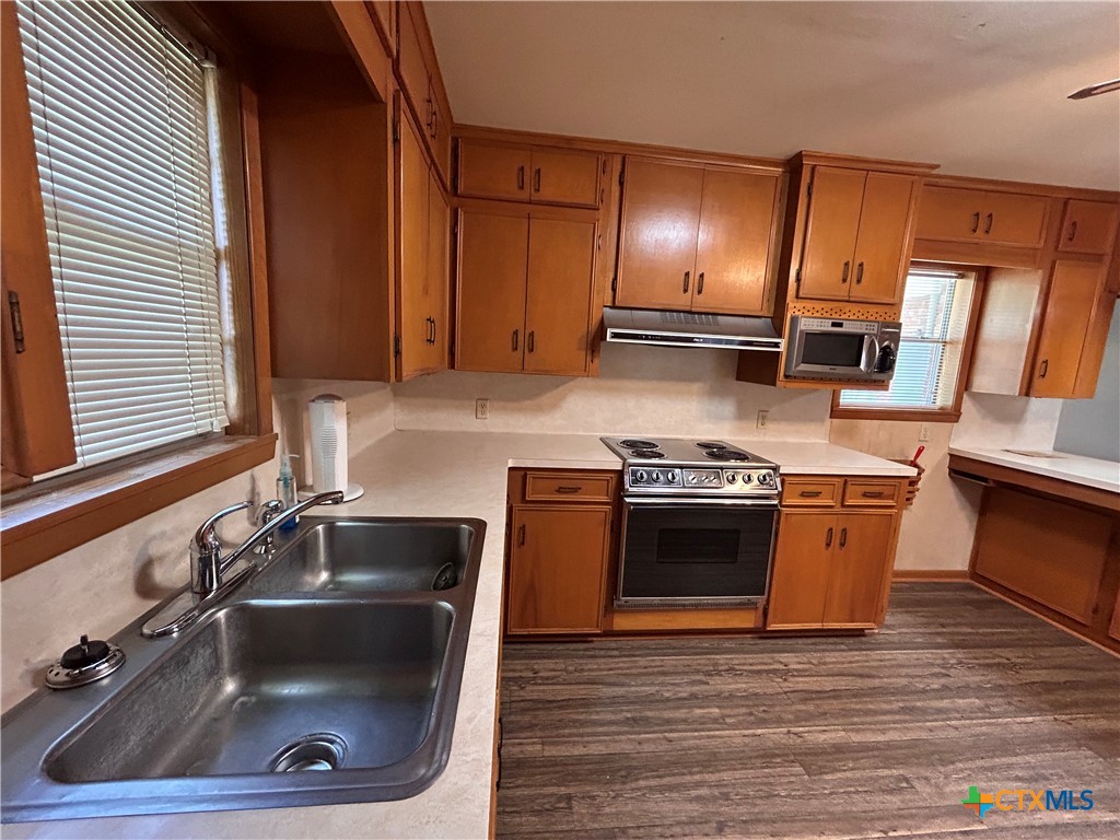 614 Apollo Drive Edna, TX 77957 - Photo 4 of 41 a kitchen with a sink and a stove with wooden floor