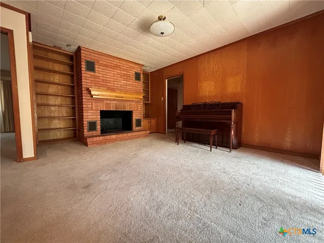 a view of empty room with a fireplace and window