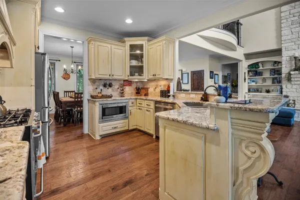 a kitchen with stainless steel appliances granite countertop a stove and cabinets