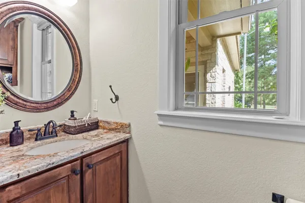 a bathroom with a granite countertop sink and a mirror