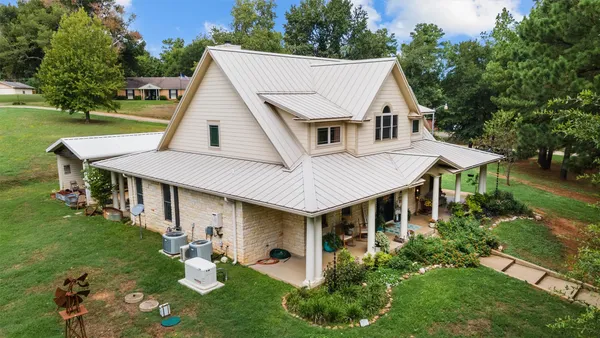 an aerial view of a house with yard porch and furniture