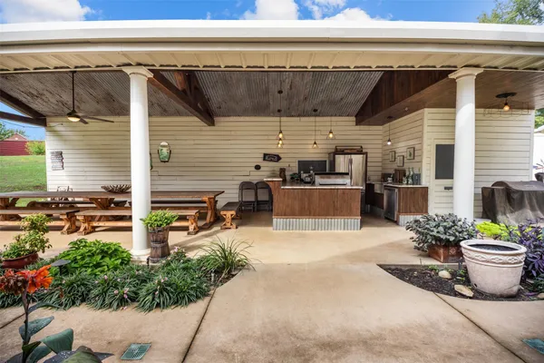 a view of a patio with table and chairs potted plants
