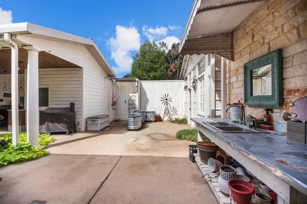 a view of backyard with wheel chair potted plants and large tree