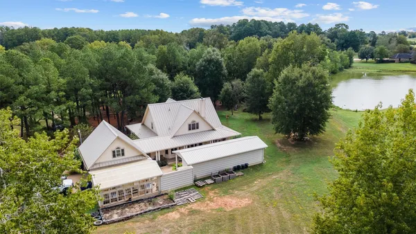 an aerial view of residential house with outdoor space and trees all around