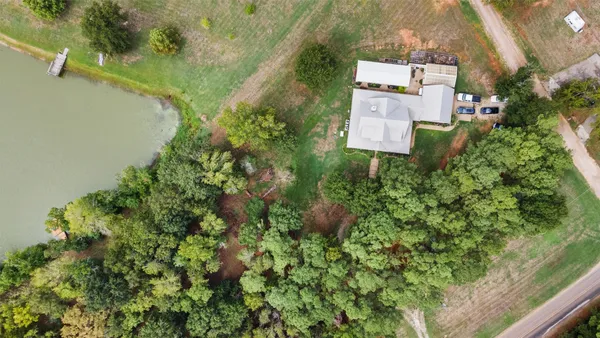 an aerial view of lake residential house with swimming pool and outdoor seating