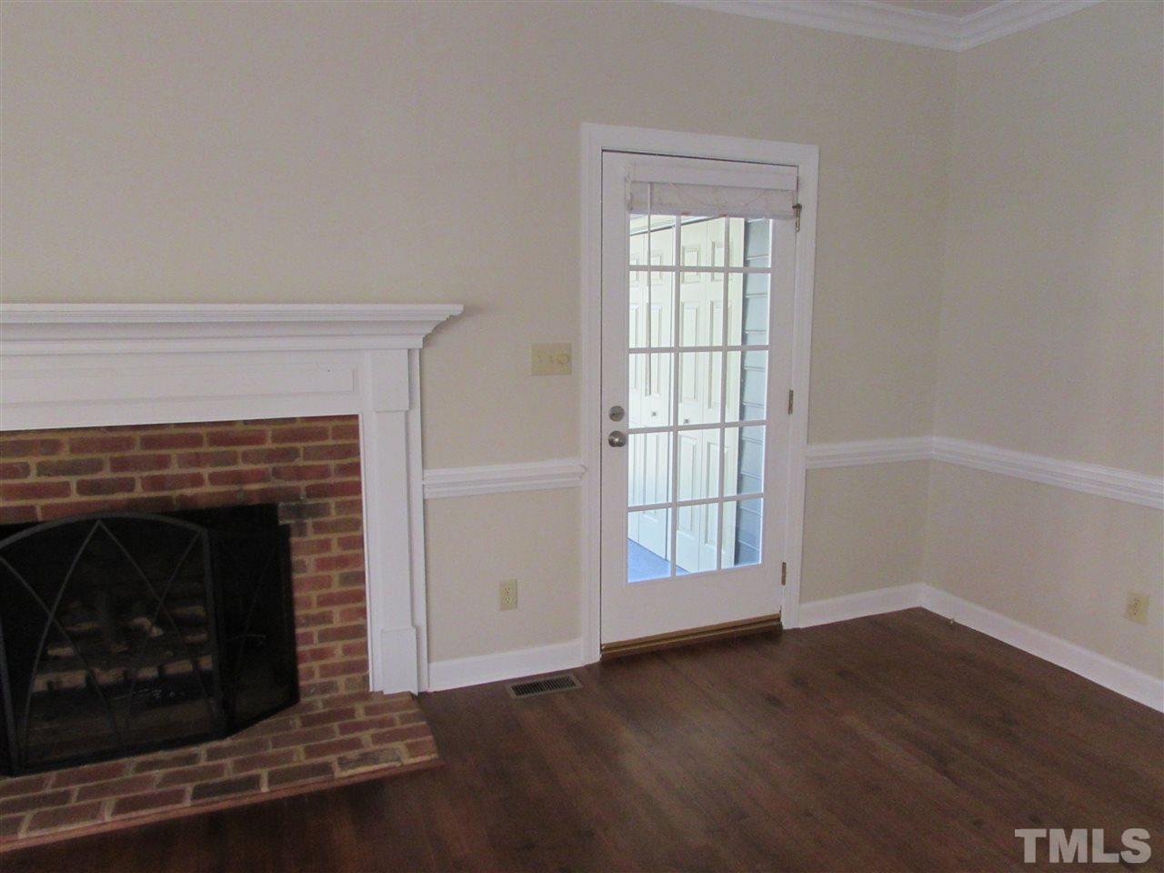 644 Weathergreen Drive Raleigh, NC 27615 - Photo 6 of 24 a view of an empty room with wooden floor and a fireplace