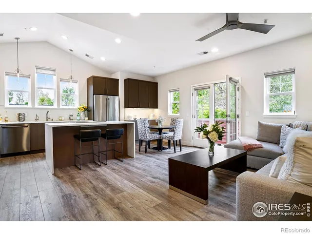 a living room with furniture kitchen view and a large window