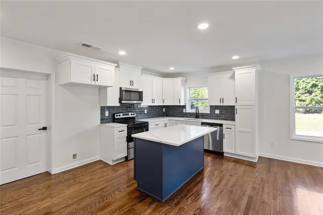 a kitchen with a sink window and cabinets