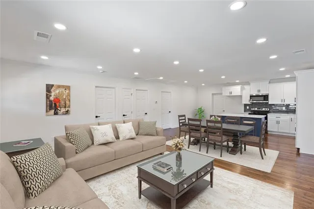 a living room with lots of furniture and kitchen view