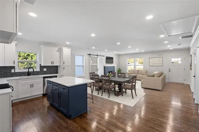 a large kitchen with kitchen island a sink table and chairs
