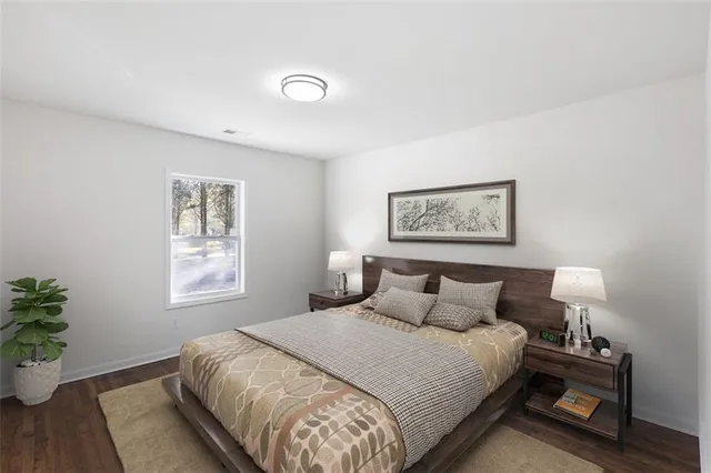 a bedroom with a large bed and a potted plant