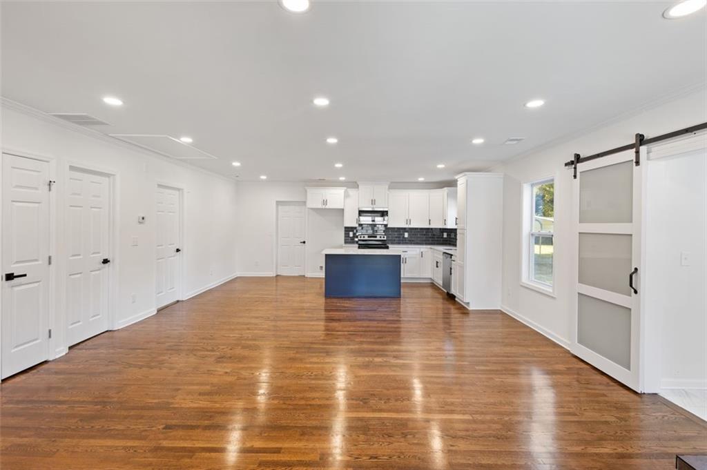 159 Pine Valley Road Bogart, GA 30622 - Photo 9 of 40 a large kitchen with kitchen island a stove a refrigerator and a sink with wooden floor
