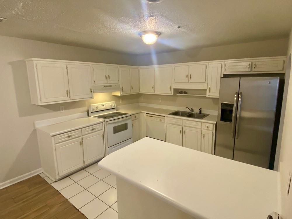 3746 Soapstone Road Decatur, GA 30034 - Photo 5 of 13 a kitchen with white cabinets and stainless steel appliances