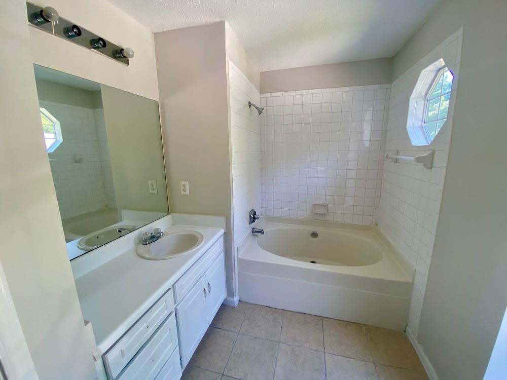 3746 Soapstone Road Decatur, GA 30034 - Photo 9 of 13 a bathroom with a tub a sink and a mirror