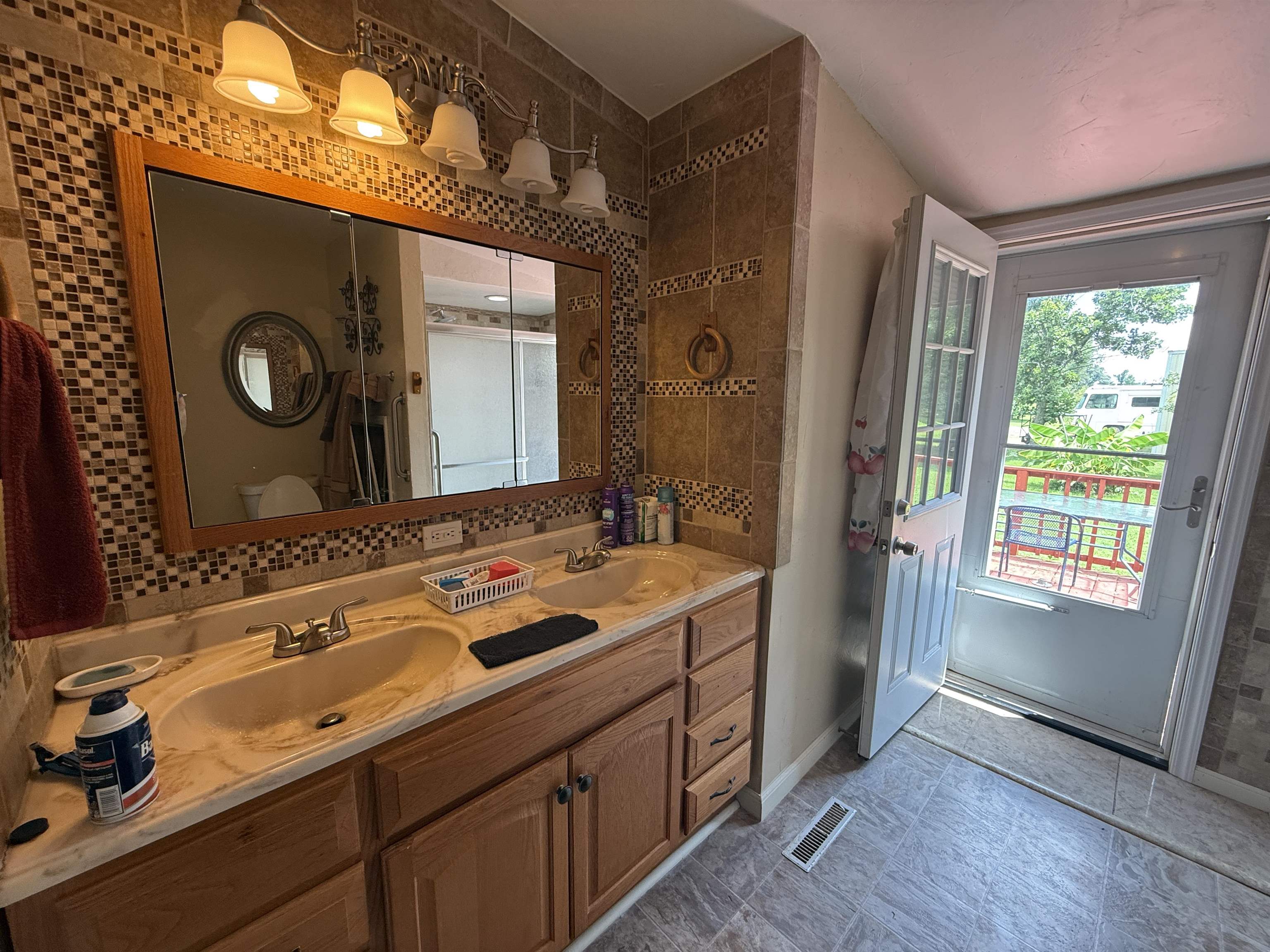 2201 Robert Johnson Road Covington, TN 38019 - Photo 22 of 25 Bathroom featuring a double vanity with built-in cabinetry and a wood-framed mirror