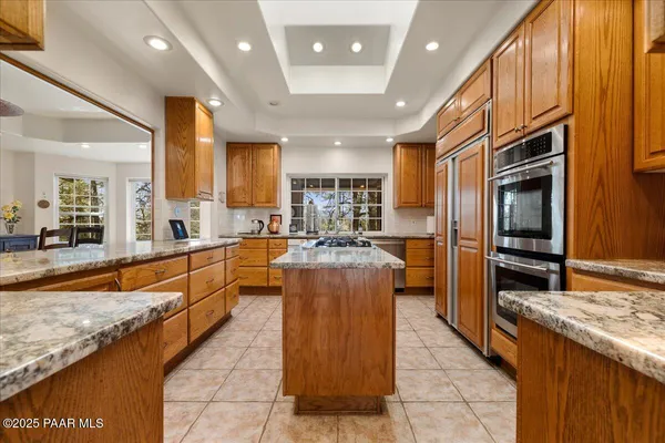 a kitchen with stainless steel appliances granite countertop a stove a sink dishwasher and cabinets with wooden floor