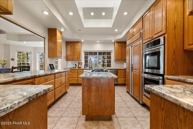 a kitchen with stainless steel appliances granite countertop a stove a sink dishwasher and cabinets with wooden floor