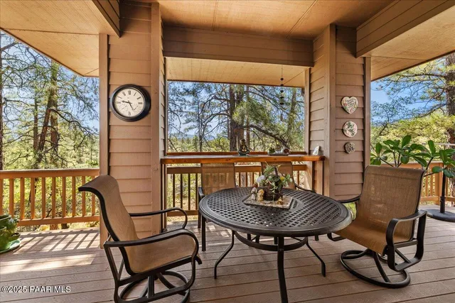 a view of a patio with table and chairs potted plants with wooden floor and floor to ceiling window