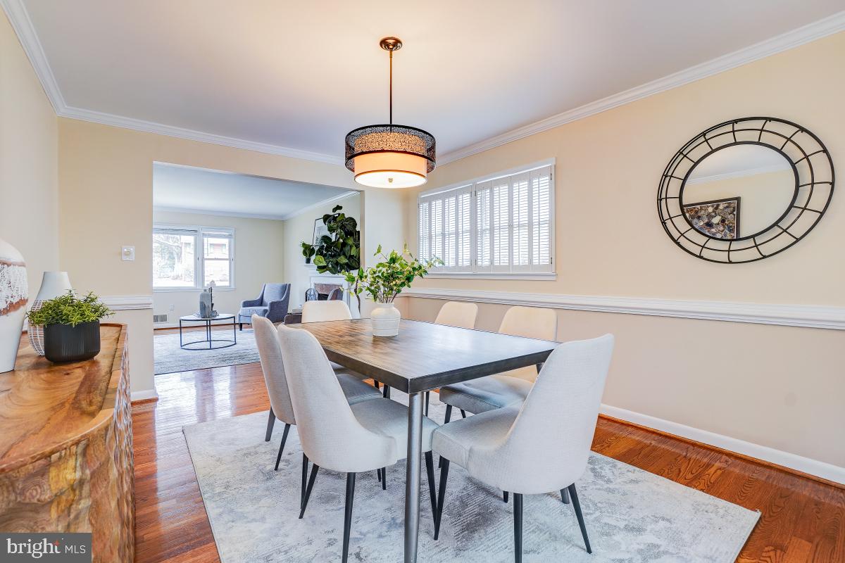 6503 Dryden Drive McLean, VA 22101 - Photo 8 of 34 a dining room with wooden floor a chandelier a wooden table and chairs