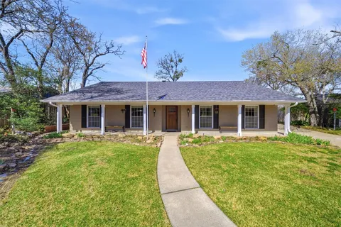 front view of a brick house with a yard