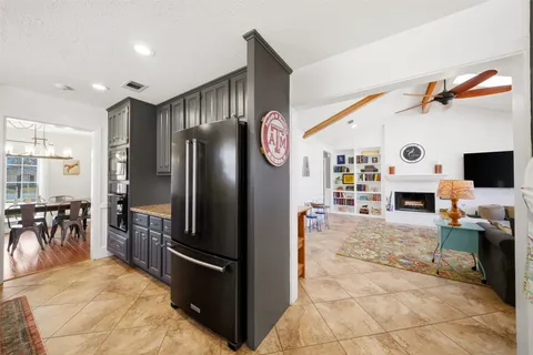 a kitchen with stainless steel appliances kitchen island granite countertop a refrigerator and a stove top oven
