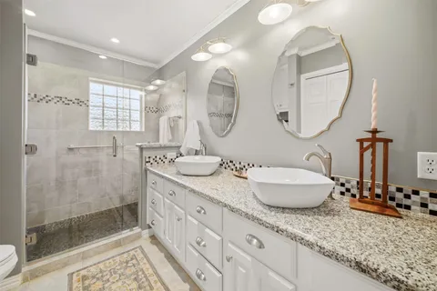 a bathroom with a granite countertop sink a mirror and a shower