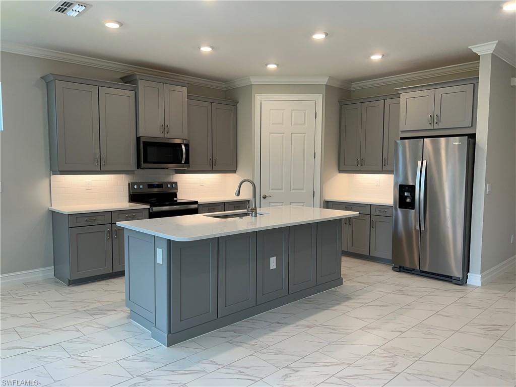 393 Deauville Loop Naples, FL 34114 - Photo 14 of 19 Kitchen with appliances with stainless steel finishes, a sink, gray cabinetry, light marble finish floors, and light countertops