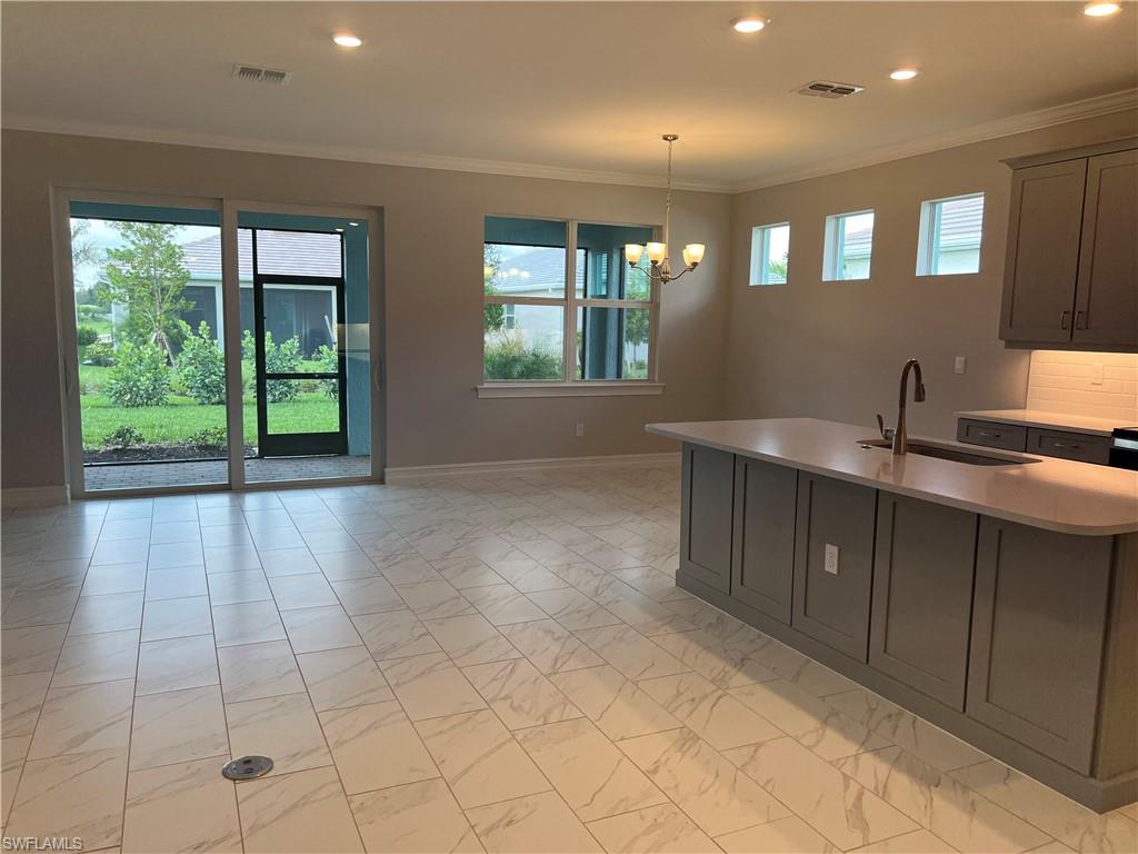 393 Deauville Loop Naples, FL 34114 - Photo 9 of 19 Kitchen featuring a sink, recessed lighting, light marble finish flooring, light countertops, and plenty of natural light