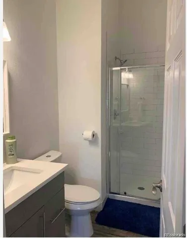 a bathroom with a granite countertop sink toilet and shower