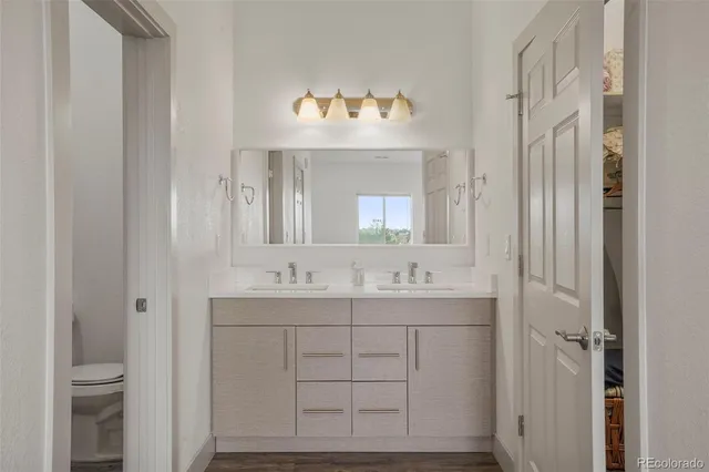 a bathroom with a sink mirror and a toilet
